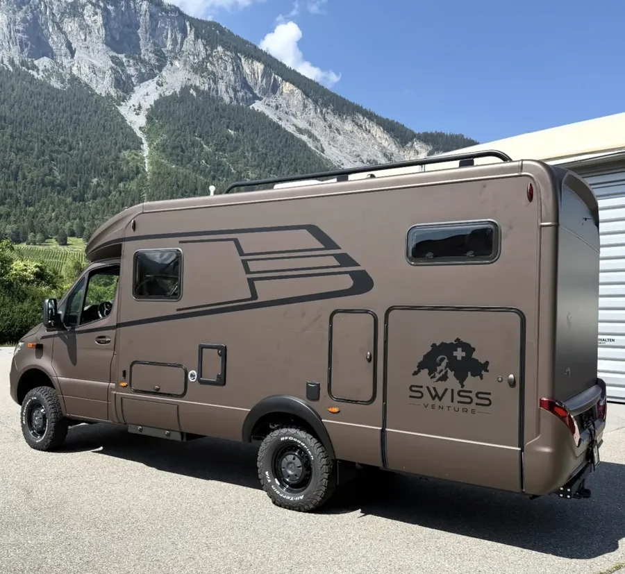 Veredeltes Swiss-Venture-4x4-Reisemobil in Bronze vor Bergkulisse